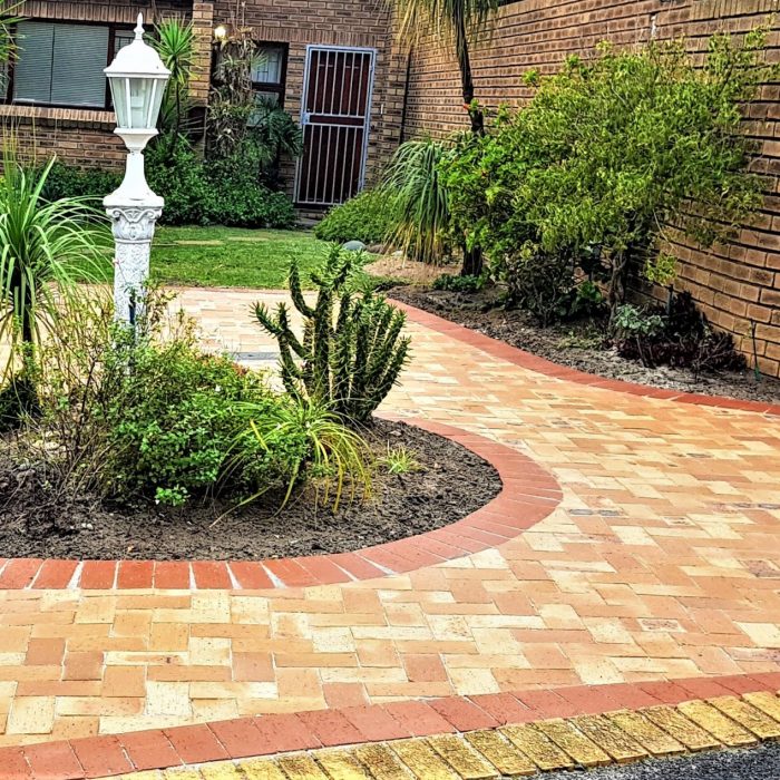 MEADOW PAVERS AROUND A FOUNTAIN WITH A RED DE HOOP BORDER